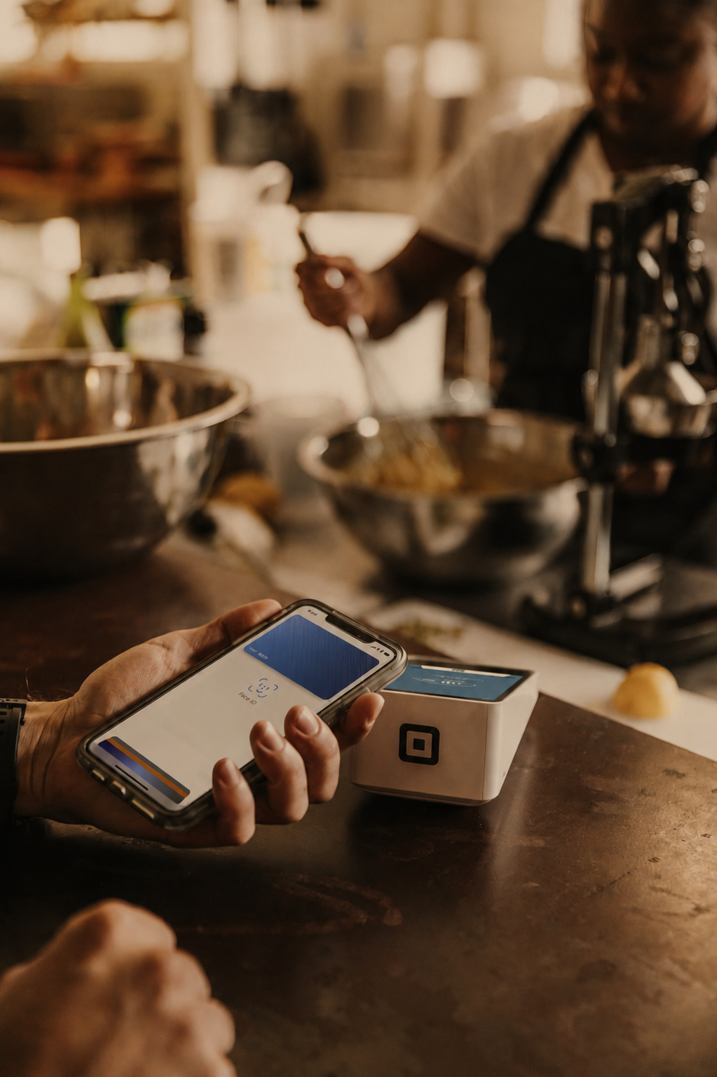 Paying by phone at a Cuseho kitchen counter to confirm a catering booking