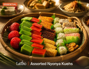 Assorted Nyonya Kuehs, rainbow kueh lapis, ang ku kueh, coconut coated traditional bites in a rattan basket. Cuseho Local Delight buffet catering, Singapore