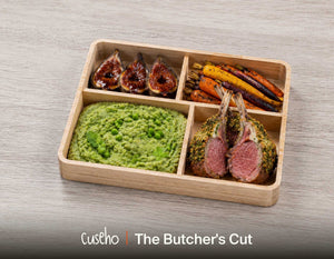 The Butcher's Cut bento in a wooden box with herb crusted lamb rack, minted pea mash, roasted heirloom carrots and balsamic glazed figs. Cuseho Modern Western bento catering, Singapore