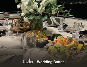 Elegant wedding dinner table with white roses, canapes and a fresh seafood platter on a yacht at night. Cuseho wedding and gala buffet catering, Singapore